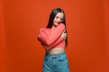 Love yourself. Pretty young teen girl embrace herself with satisfied pleased expression, positive...