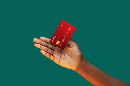 Close up african american female hand and levitating template Bank credit card with online service on green backgroundの写真素材