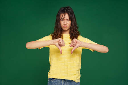 Dissatisfied young girl show thumbs down gesture, give negative feedback on service, does not...