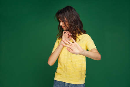 Displeased young girl doing stop gesture turn away from something disgusting unpleasant on green...