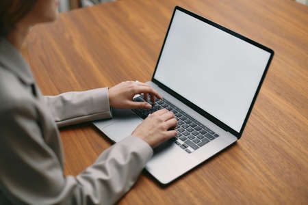 Computer mockup blank screen for advertisement. Closeup female typing on modern laptop keyboard...