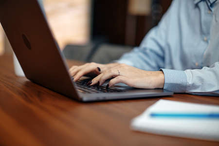 Close up female working on computer laptop typing on keyboard, writing e-mail. E-learning, online...