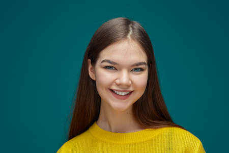 Funny beautiful happy girl student looking at camera, toothy smiling, headshot studio portrait. Positive emotionsの写真素材