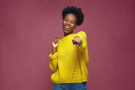 Happy young african american girl pointing to camera, laughing at joke, having fun. Humor, positive emotion conceptの写真素材