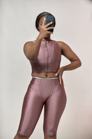 Stylish african american young girl holding phone makes selfie photo for her body positive blog in social mediaの写真素材