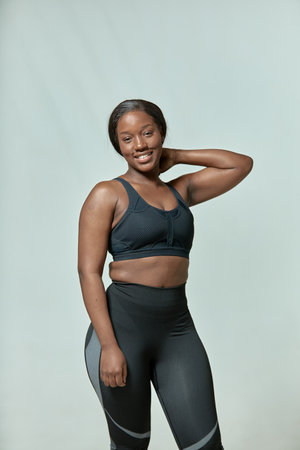 Happy african american woman wears sportive clothes posing. Black girl in sportswear. Body positive and slimming conceptの写真素材