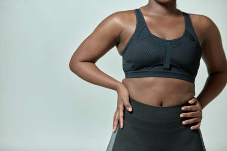 African american girl wearing sportive clothes showing torso with fat folds, closeup, copyspace. Body positive, slimmingの写真素材
