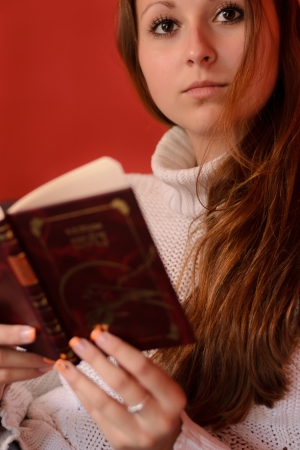 Beautiful young woman reading an book at home の写真素材