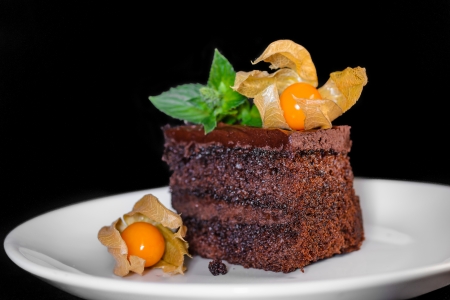 Detail of home made chocolate cake with Bladder cherry on black background の写真素材