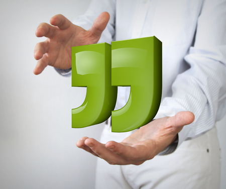 green reflective quotes sign between handsの写真素材