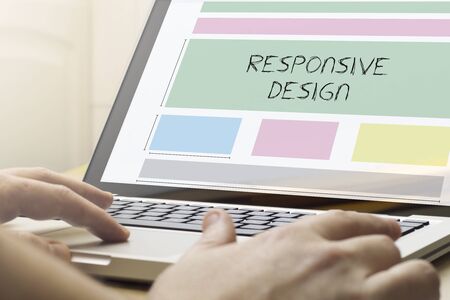 responsive design concept: man using a laptop with responsive wireframeの写真素材