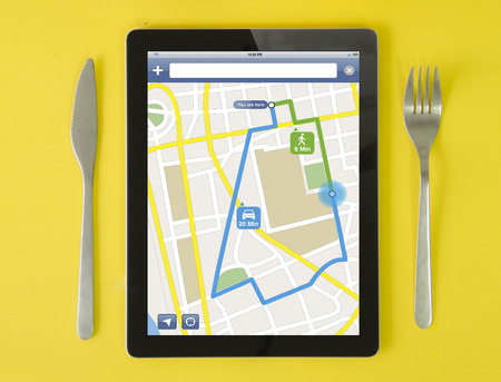 tablet gps concept: hipster breakfast with route planner app on a tablet screen. screen graphics are...