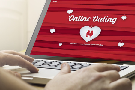 online dating concept: man using a laptop with online dating website on the screen. Screen graphics are made up.の写真素材