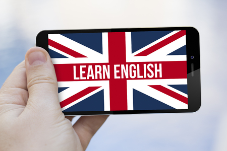 languages learning concept: hand holding an learn english 3d generated smartphone. Screen graphics are made up.の写真素材