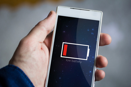 man hand holding low battery smartphone.