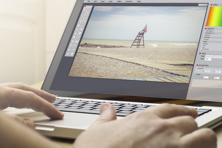 photography concept: man using a laptop with photo editor on the screen. Screen graphics are made...