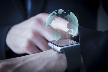 close up of hand with world hologram on smartwatchの写真素材