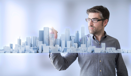 businessman sketching holographic city skyline