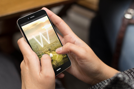 mobile design concept: girl using a digital generated phone with fresh and modern website on the screen. All screen graphics are made up.の写真素材