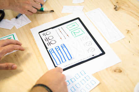 close up view of hands designing tablet app