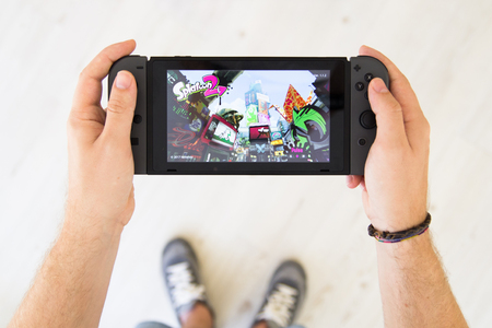 GIJÃN, SPAIN - AUG 10, 2017: Man playing Splatoon 2 on a Nintendo Switch, a video game console developed by Nintendoのeditorial素材