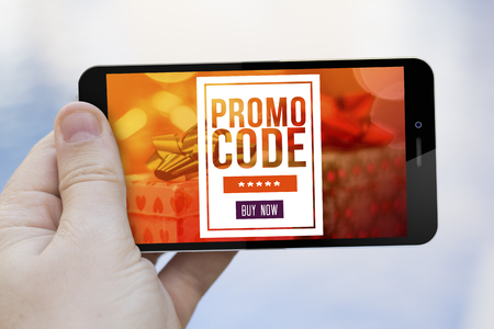 mobile marketing concept: hand holding a gift voucher on smartphone screen. Screen graphics are made up.の写真素材