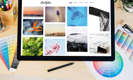 tablet pro touchscreen on desktop with creative photo portfolio on screenの写真素材