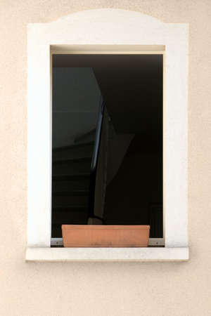 Indoor stairs view over a flower pot through the windowの写真素材