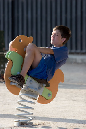 Child bouncing on horse toyの写真素材