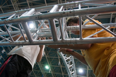 Two workers raising metalic structure