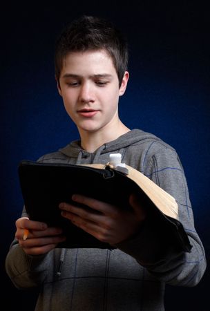 Young man reading and studying in his Bibleの写真素材