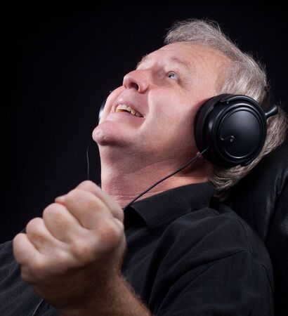 Happy senior listening something in his headphonesの写真素材