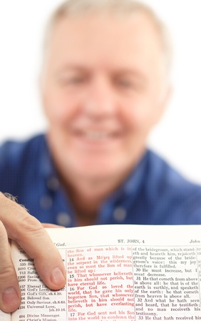 Senior pastor showing an important Scripture promise (For God so loved the world, that he gave his only begotten Son, that whosoever believeth in Him should not perish, but have everlasting life.)の写真素材