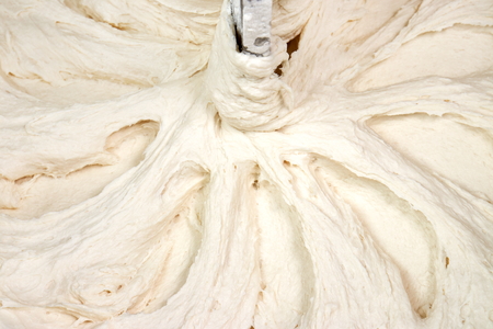 Dough kneading, mixed, in a professional mixer as backgroundの写真素材