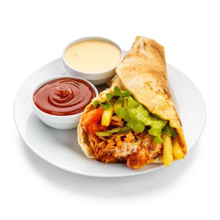 Delectable flavors of a shawarma platter, featuring a symphony of marinated meat, crispy fries, melted cheese, tangy pickles, fresh tomatoes, leafy greens, and a drizzle of delectable sauces wrapped in soft pita breadの写真素材