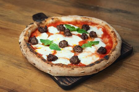 Freshly baked pizza on a wooden tableの写真素材