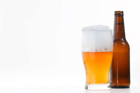Glass and bottle of cold beer on white backgroundの写真素材