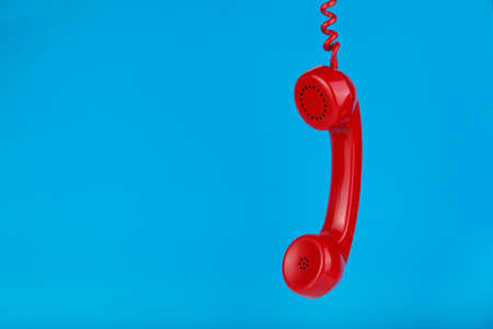 Vintage red telephone on blue backgroundの写真素材