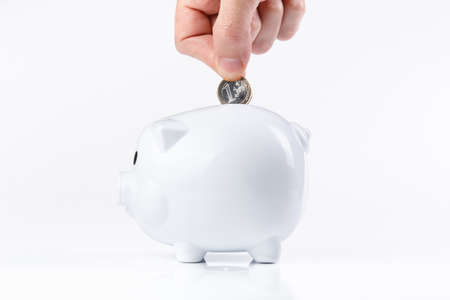 Hand putting money in a piggy bank.の写真素材