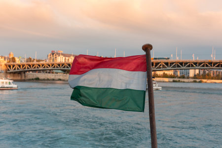 Boat trip on the danube in the city of Budapest, flag in the foreground, a Bridgeの写真素材