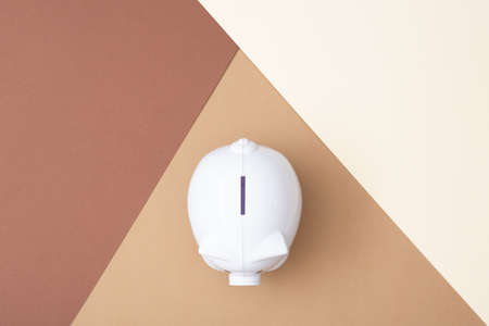 White piggy bank viewed from above with a Brown colored background made from card stockの写真素材