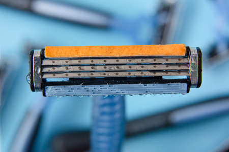 Detail close-up razor blade and other blades at the bottom on a background of bluish colorsの写真素材