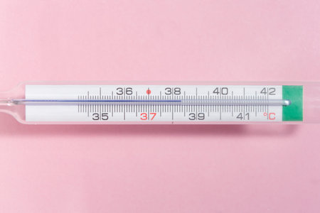 detail of a thermometer at 38 degrees Celsius on a pink background