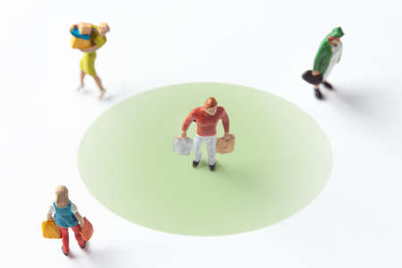 miniature people figures on white background with safety distance marked on the groundの写真素材
