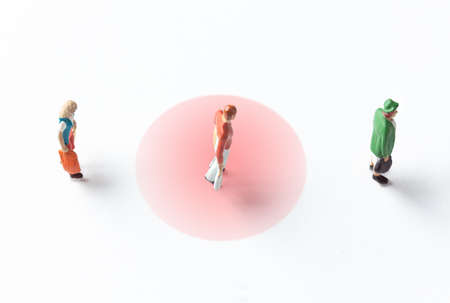 miniature people figures on white background with safety distance marked on the groundの写真素材