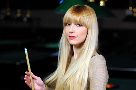 portrait of a beautiful young blonde playing snooker  billiards の写真素材