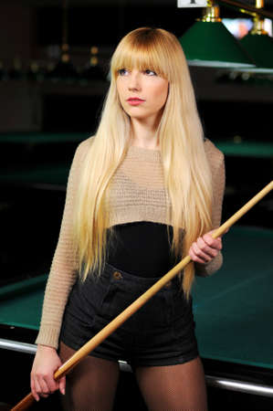portrait of a beautiful young blonde playing snooker  billiards の写真素材