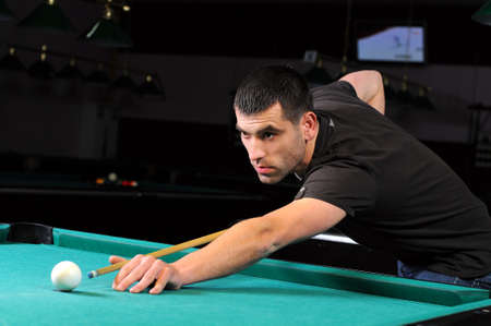 Man playing snooker in the dark club の写真素材