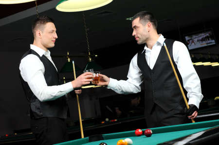 Young people with drinks in their hands to play snooker at the clubの写真素材