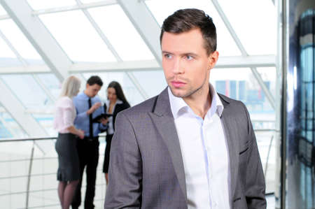 Portrait of young businessman looking at camera in working environmentの写真素材